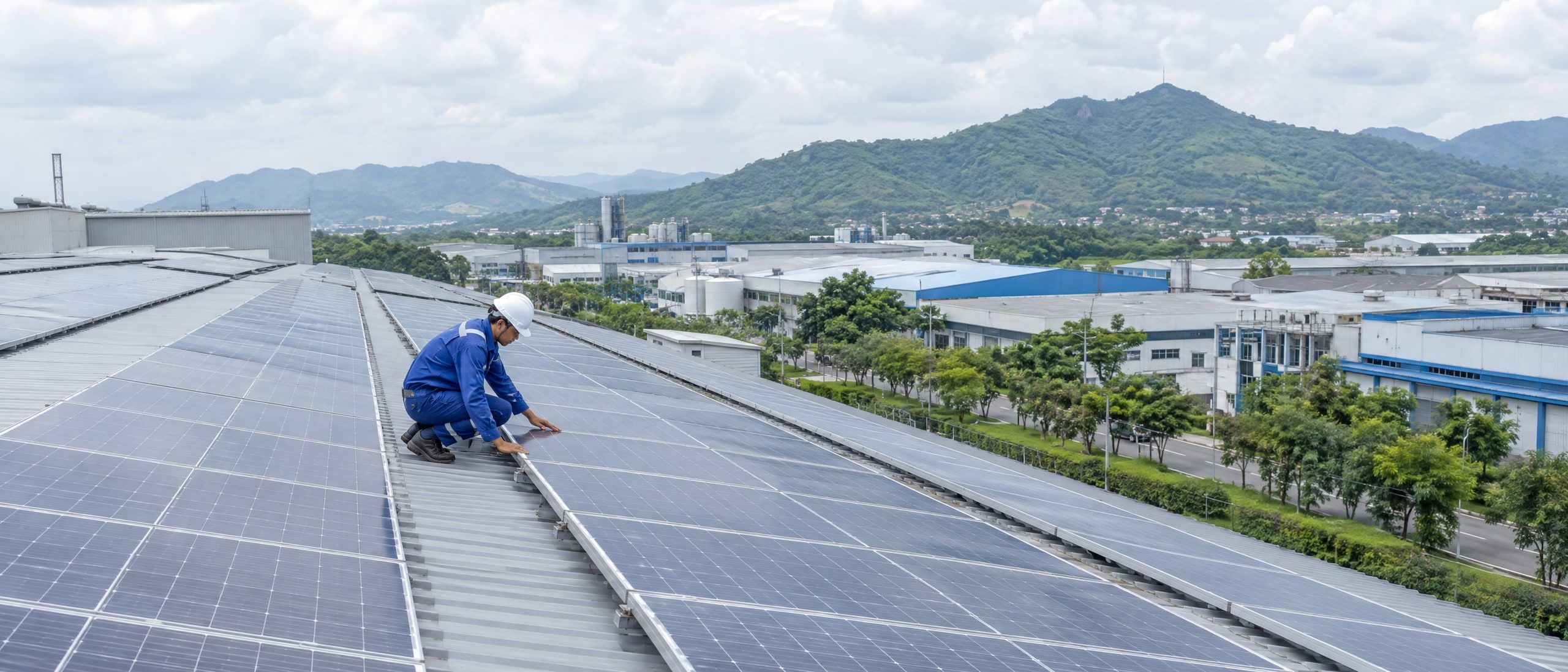 An engineer checking rooftop solar panels on a factory in West Java